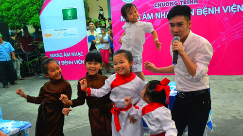 Bé Thảo (2 tuổi, phía sau) ở Bệnh viện Nhi Đồng 1 lên sân khấu biểu diễn cùng ca sĩ Quang Hà 