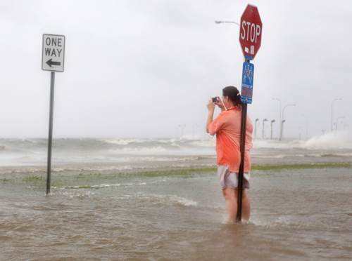 Một người dân đứng chụp hình ở hồ Pontchartrain, thành phố thành phố New Orleans khi bão Isaac đổ bộ vào thành phố này - Ảnh: Reuters
