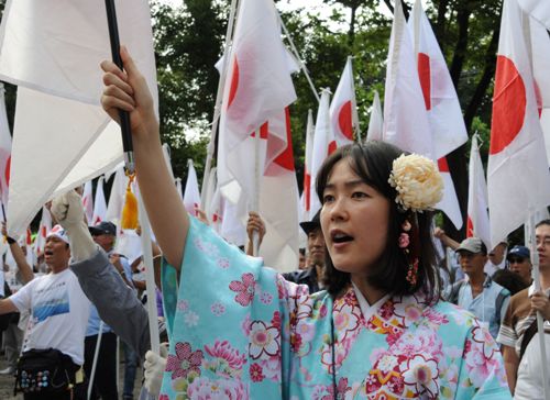 Một phụ nữ Nhật trong trang phục truyền thống Kimono giơ cao cờ biểu tình chống Trung Quốc vào ngày 22.9 - Ảnh: AFP