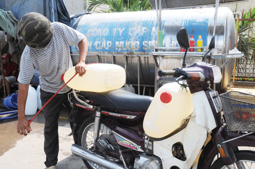Nhiều hộ dân ở TP.HCM vẫn phải mua từng bình nước về dùng - Ảnh: Diệp Đức Minh