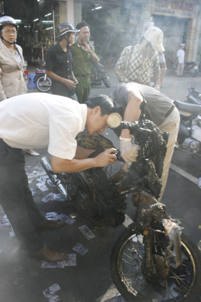 Các lực lượng chức trách đang khám nghiệm chiếc xe máy tự cháy 