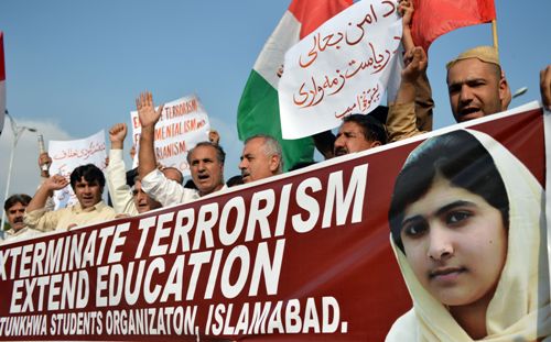 Những người biểu tình ở Pakistan cần khẩu ngữ có hình của Malala (gốc phải), kêu gọi chấm dứt khủng bố mở rộng giáo dục cho nữ giới - Ảnh: AFP