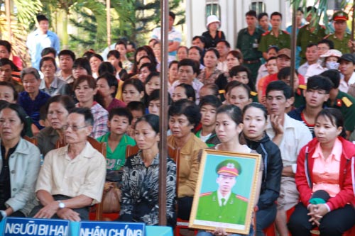Người thân của chiến sĩ Lê Thanh Tâm mang theo di ảnh của anh đến phiên tòa