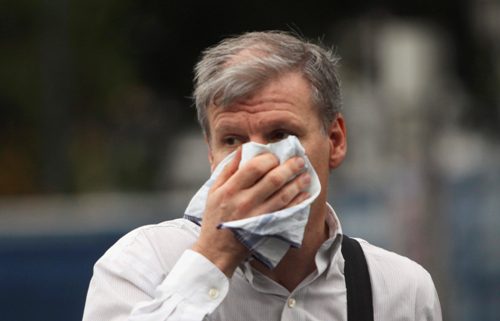 Một người đàn ông dùng khăn tay che mũi tránh khói độc ở Buenos Aires - Ảnh: Reuters