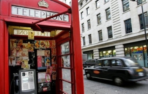 Quảng cáo gái mại dâm dán đầy trong thùng điện thoại công cộng ở London - Ảnh: AFP