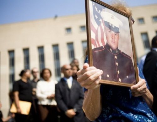 Người thân gia đình cầm di ảnh của một binh sĩ thiệt mạng trong vụ đánh bom năm 1983 - Ảnh: AFP