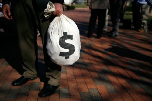 Cảnh sát quân sự bỏ số tiền 10.000 USD mà cặp nam nữ nhặt được vào trong túi màu trắng - Ảnh: AFP