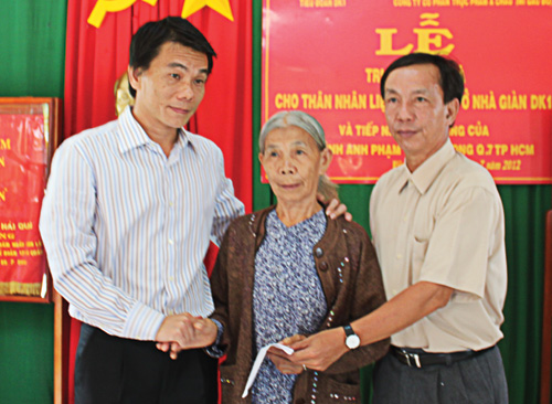 Tổng biên tập Báo Thanh Niên (bên phải) và Phó tổng giám đốc Công ty Á Châu trao quà cho mẹ liệt sĩ Lê Đức Hồng - Ảnh: Nguyễn Long