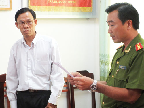 Cơ quan điều tra đọc quyết định khởi tố bị can đối với ông Đặng Xuân Quỳnh - Ảnh: C.T.V