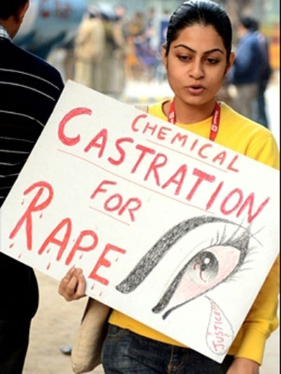 Một phụ nữ Ấn Độ mang tấm biển yêu cầu thiến dâm tặc 