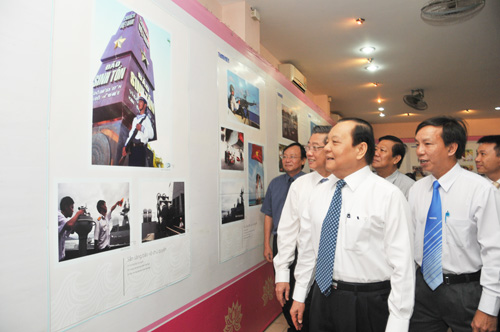 Anh Nguyễn Quang Thông (bìa phải) giới thiệu các bộ ảnh với ông Lê Thanh Hải cùng các lãnh đạo TP.HCM 