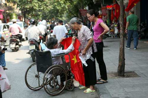 Cụ Nhiễu, 80 tuổi, bị liệt, tự mình lăn xe đến mua cờ tang trên phố Hàng Bông ngày 11.10 - d
