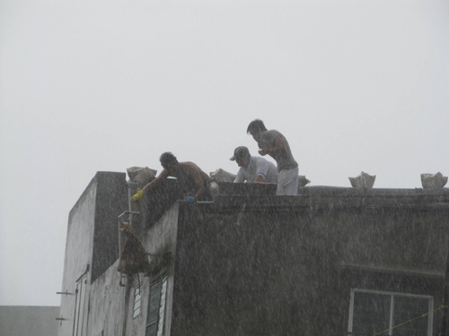 Trong mưa to, gió lớn, nhiều người dân vẫn không ngần ngại leo lên cao để chèn chống nhà cửa, rất nguy hiểm 1