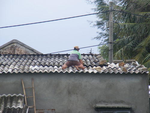 Một người dân ở thị trấn Thuận An (H.Phú Vang, Thừa Thiên – Huế) gia cố chằng níu nhà cửa để phòng chống cơn bão số 11