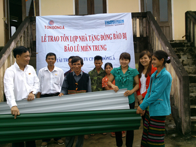 Đại diện Báo Thanh Niên và Tôn Đông Á trao tôn lợp nhà cho người dân tại nhà sinh hoạt cộng đồng bản Khe Trăn -d