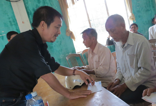 Đại diện Báo Thanh Niên trao quà cho cụ Ngô La, 84 tuổi, trú thôn Lộc Đông, xã Tam Phú, nhà tốc mái nặng - Ảnh: Tuyết Khoa