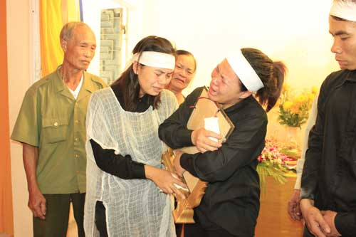 Chị Đinh Thị Kim Xoa (thứ 2 từ trái qua) là vợ anh Nam cùng người thân khóc nghẹn ôm di ảnh của anh Nam trước giờ an táng