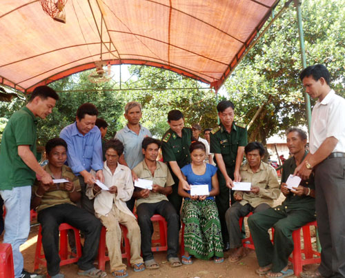Đại diện Báo Thanh Niên và Bộ đội biên phòng Bình Phước trao tiền cho các gia đình nạn nhân - d