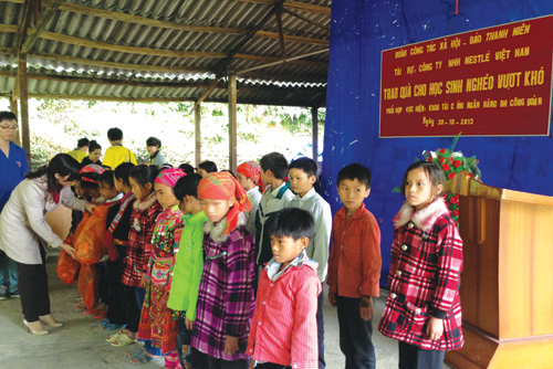 Cô giáo Nguyễn Thị Liên, Hiệu trưởng Trường tiểu học Hồ Thầu, trao quà cho các em