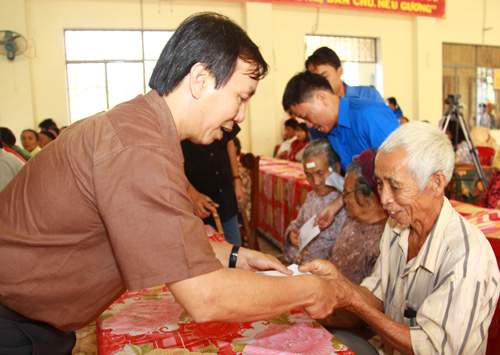 Anh Nguyễn Quang Thông trao tiền cho các cụ già neo đơn tại xã Bình Dương, H.Thăng Bình