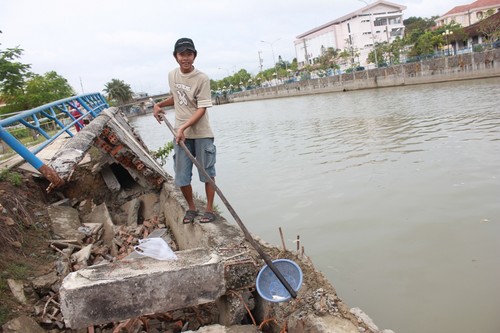 Người dân gắn cây vào rỗ để vớt