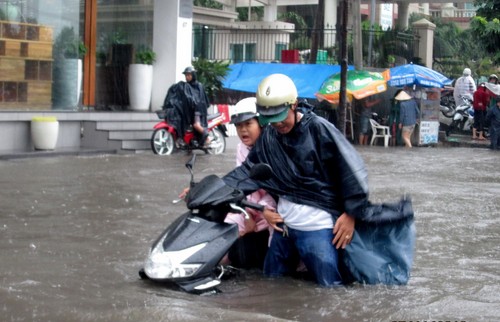 Cha đưa con đến trường học bị ngập sâu tại đường Nguyễn Hữu Cảnh