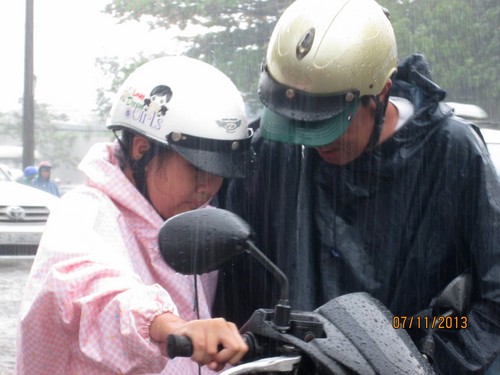 Cha đưa con đến trường học bị ngập sâu tại đường Nguyễn Hữu Cảnh