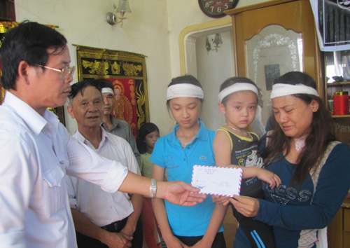 Ông Nguyễn Quốc Tuấn, Phó Chủ tịch UBND thị trấn Đức Thọ, H.Đức Thọ (Hà Tĩnh) trao tiền hỗ trợ của báo Thanh Niên cho gia đình nạn nhân Nguyễn Cảnh Bình