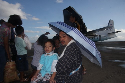 Hai bố con người đàn ông Tacloban đang chờ chuyến bay qua Cebu