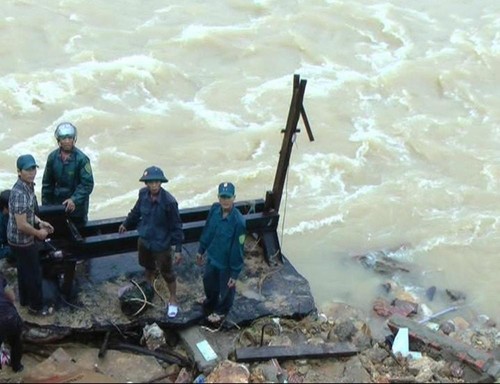 Lực lượng chức năng xã Phước Hiệp (H.Phước Sơn) giúp dân tìm kiếm đồ đạc sau khi nhà bị sạt xuống sông (Ảnh: Trọng Ý)