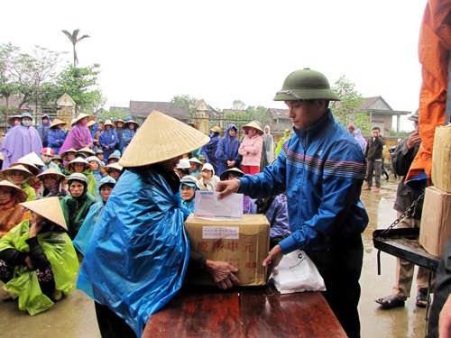 Đại diện Báo Thanh Niên trao hàng, tiền cho người dân Quảng Sơn