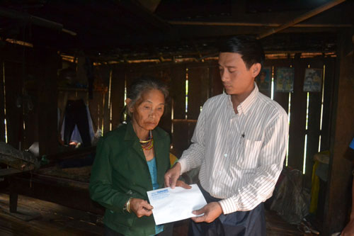 Trao tien: Đại diện UBND xã Sơn Dung, H.Sơn Tây (Quảng Ngãi) trao tiền của bạn đọc Báo Thanh Niên giúp gia đình vợ chồng anh Đinh Văn Lang d