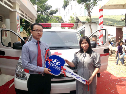 Đại diện Tổ chức từ thiện quốc tế Rotary (bên trái), trao chìa khóa tặng xe cứu thương cho chị Huỳnh Tiểu Hương – Giám đốc Trung tâm Nhân đạo nuôi dạy trẻ khuyết tật Quê Hương