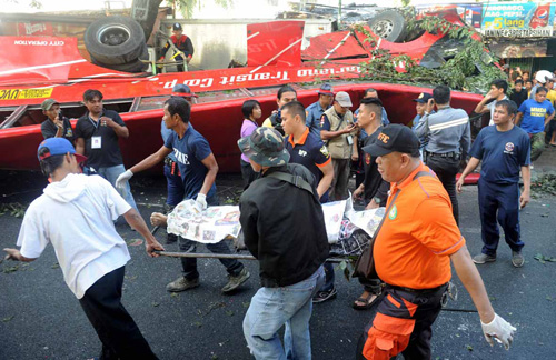 Nhân viên y tế Philippines chuyển thi thể nạn nhân ra khỏi chiếc xe buýt gặp nạn - Ảnh: AFP