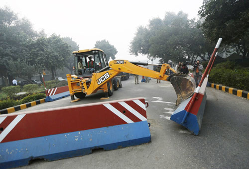 Xe cẩu xô đổ hàng rào bê tông trước Đại sứ quán Mỹ ở New Delhi - Ảnh: Reuters 