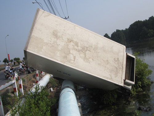 Xe tải lạc tay lái “nằm” vắt vẻo trên đường ống dẫn nước