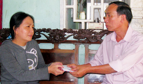 Đại diện Báo Thanh Niên trao tiền bạn đọc giúp cô giáo Võ Thị Bích Thảo 