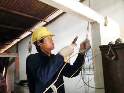 Thanh niên tình nguyện của Công ty điện lực Củ Chi sửa chữa điện cho người nghèo tại xã Bình Hưng, huyện Bình Chánh