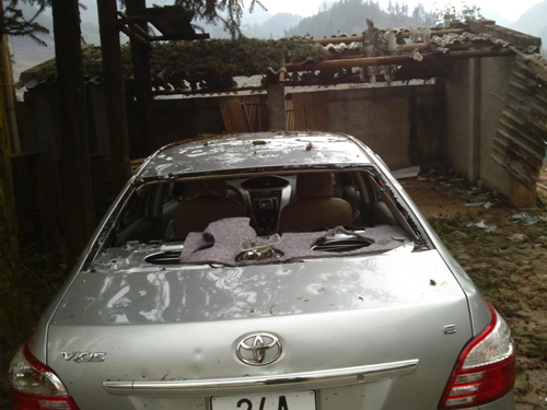 Một chiếc ô tô du lịch để ngoìa trơì bị vỡ kính hoàn toàn do mưa đá gây ra