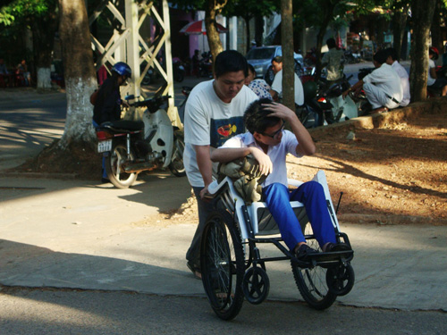 Thí sinh Lê Lợi do ngồi xe lăn nên phải có sự giúp đỡ của người thân mới đến được trường thi