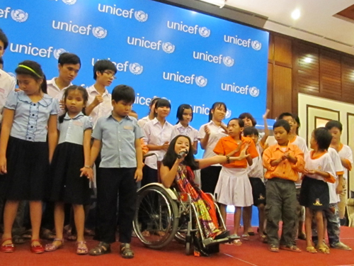  “Cô bé thủy tinh” Nguyễn Phương Anh (ngồi xe lăn) cùng các em nhỏ khuyết tật cùng hát với nhau tại lễ công bố