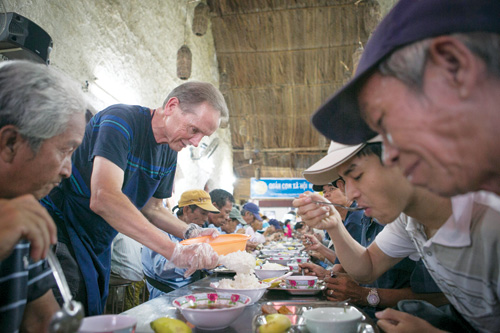 Ông “Chon” đang châm cơm thêm cho người nghèo tại quán cơm 2.000 đồng Nụ Cười 1
