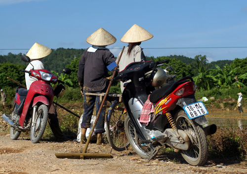 Dựng xe máy, các phụ nữ Vũ Lao đang chuẩn bị xuống ruộng