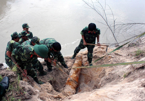 Tháo dỡ bom dưới bờ sông d