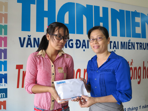 Đại diện Báo Thanh Niên trao tiền cho sinh viên Thu Thảo (bên trái) - d