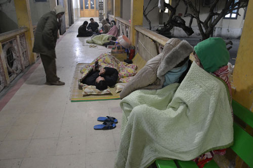 Người nhà bệnh nhân co ro trong giá rét về đêm ở hành lang bệnh viện - Ảnh: Nguyễn Tuấn