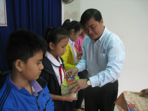 Phó tổng biên tập Báo Thanh Niên Nguyễn Ngọc Toàn trao quà cho trẻ em ở Q.Tân Bình - Ảnh: Phan Phương