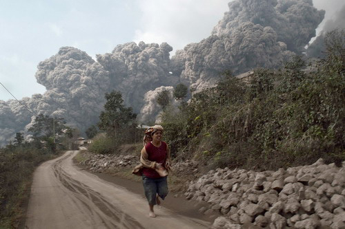 Một người dân làng chạy nạn khi núi lửa phun vào ngày 1.2 – Ảnh: Reuters