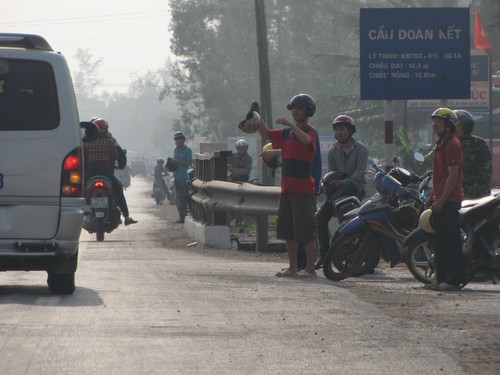 Người dân xã Hưng Thủy ra hiệu cho xe khách để kiếm tiền từ việc chở người trung chuyển qua trạm CSGT