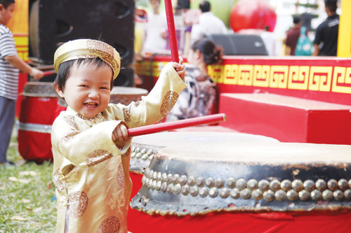 Bé thích thú đánh trống khai hội